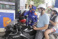 Mua bán xăng dầu tại một điểm kinh doanh của Petrolimex. (Ảnh: Trần Việt/TTXVN)