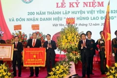 Thừa ủy quyền của Chủ tịch nước, Bí thư Tỉnh ủy Bắc Giang Dương Văn Thái trao Danh hiệu Anh hùng Lao động thời kỳ đổi mới cho Đảng bộ, chính quyền và nhân dân huyện Việt Yên. (Ảnh: Đồng Thúy/TTXVN)