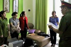 Cơ quan công an đọc lệnh bắt Nguyễn Thị Huyền Trang-áo xám. (Nguồn: vov.vn)