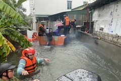 Lực lượng chức năng sơ tán 200 hộ dân phường Bến Thủy, thành phố Vinh đến nơi an toàn. (Ảnh: Bích Huệ/TTXVN)