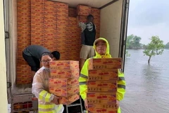 Vận chuyển lương thực hỗ trợ người dân vùng lũ. (Ảnh: TTXVN phát)