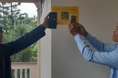 Các đại biểu thực hiện quét mã QR tra cứu thông tin về di tích Công viên Võ Thị Sáu tại thị trấn Đất Đỏ, huyện Đất Đỏ. (Ảnh: Hoàng Nhị/TTXVN)