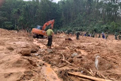 Lực lượng cứu nạn tìm kiếm người mất tích tại khu vực nhà kiểm lâm ở Tiểu khu 67. (Ảnh: TTXVN phát)