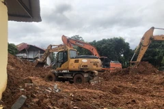 Các phương tiện nỗ lực tìm kiếm người bị nạn trong vụ sạt lở đất. (Ảnh: TTXVN phát)