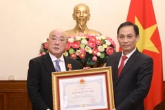 Thứ trưởng Bộ Ngoại giao Lê Hoài Trung trao Huân chương Hữu nghị cho Cố vấn đặc biệt Nội các Thủ tướng Nhật Bản Iijima Isao. (Ảnh: Văn Điệp/TTXVN)