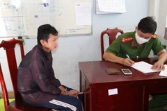 Cảnh sát điều tra Công an thành phố Mỹ Tho lấy lời khai đối tượng Dũng. (Ảnh: Hữu Chí/TTXVN)