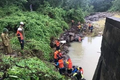 Lực lượng chức năng tiến hành trục vớt thi thể anh Thái Bá Thuận. (Ảnh: TTXVN phát)