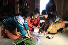 Gạo nếp nương sau khi giã mịn được gói vào lá chuối theo hình tròn. (Ảnh: Hữu Quyết/TTXVN)