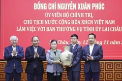 Chủ tịch nước Nguyễn Xuân Phúc tặng đồ lưu niệm cho Ban Thường vụ Tỉnh ủy Lai Châu. (Ảnh: Thống Nhất/TTXVN)