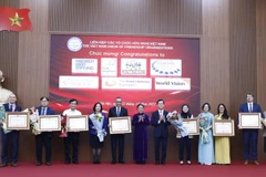 Đại sứ Nguyễn Phương Nga, Chủ tịch Liên hiệp các tổ chức hữu nghị Việt Nam và Thứ trưởng Bộ Ngoại giao Hà Kim Ngọc trao Bằng khen của Thủ tướng Chính phủ tặng các tổ chức phi Chính phủ nước ngoài. (Ảnh: An Đăng/TTXVN)