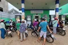 Người dân xếp hàng chờ đổ xăng với hạn mức đổ tối đa 30.000 đồng/lần tại cửa hàng xăng dầu Tấn Tài (phường Tấn Tài, thành phố Phan Rang-Tháp Chàm). (Ảnh: Nguyễn Thành/TTXVN)