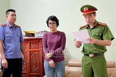 Cán bộ công an đọc lệnh khám xét nơi làm việc của bị can Dương Thị Nga. (Nguồn: Báo Bắc Giang)