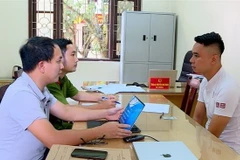Đối tượng Nguyễn Duy Tùng (phải) tại Cơ quan công an. (Ảnh: TTXVN phát)