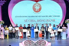 Ban tổ chức trao bằng khen và kỷ niệm chương cho các gia đình. (Ảnh: Minh Đức/TTXVN)