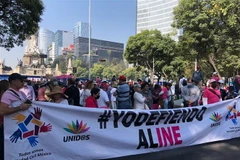 Dòng người biểu tình diễu hành qua các trục đường chính cùng đồng phục áo trắng in chữ 'Bảo vệ INE.' (Ảnh: Trương Phi Hùng/TTXVN)