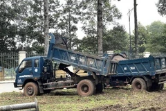 Các phương tiện vận chuyển, đổ chất thải trái phép bị tạm giữ. (Ảnh: TTXVN phát)