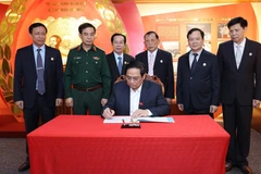 Thủ tướng Phạm Minh Chính viết lưu bút sau khi thăm Phòng truyền thống Hội Cựu chiến binh Việt Nam. (Ảnh: Dương Giang/TTXVN)