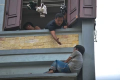 Lực lượng cứu hộ đã khuyên người đàn ông vào bên trong nhưng không thành công. (Ảnh: PV/Vietnam+)