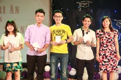 15 bạn học sinh tròn 18 tuổi rất vui mừng khi được cầm trên tay những tấm thẻ cử tri đầu tiên. (Ảnh: Minh Sơn/Vietnam+)