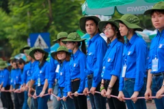 Hình ảnh những sinh viên tình nguyện Đại học Bách khoa lập ‘hàng rào sống’ giúp thí sinh sang đường gây ấn tượng với thí sinh và phụ huynh. (Ảnh: Minh Sơn/Vietnam+)