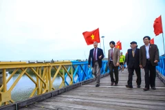 Đại sứ Mỹ bước qua vạch trắng kẻ ngang. Trong quá khứ, đây là ranh giới phân chia 2 nửa cây cầu Hiền Lương cũng là chia nửa đất nước. (Ảnh: Minh Sơn/Vietnam+)