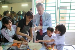 Đại sứ Mỹ hào hứng làm bánh nướng, bánh dẻo cùng các em nhỏ nạn nhân chất độc da cam dioxin. (Ảnh: Minh Sơn/Vietnam+)