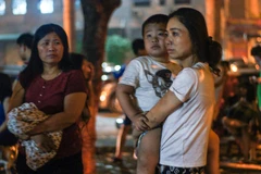 Nhiều em nhỏ ngơ ngác khi đang ngủ ngon nhưng lúc tỉnh dậy lại thấy đang ở ngoài đường trong cảnh hỗn loạn. (Ảnh: PV/Vietnam+)