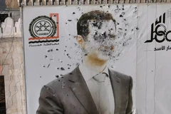 Bức ảnh chân dung Tổng thống Assad bị đạn xuyên nát tại Syria. (Nguồn: France 24)