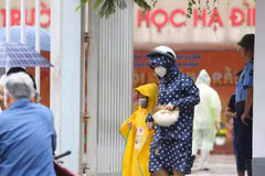 Các bậc phụ huynh đón con nhỏ luôn đeo khẩu trang tại Trường Tiểu học Hạ Đình, cách hiện trường vụ cháy Nhà xưởng Công ty Rạng Đông chưa đến 1km. (Ảnh: Thành Đạt/TTXVN)