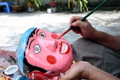 Mặt nạ được những nghệ nhân tỉ mẩn vẽ mô phỏng lại các nhân vật dân gian. (Ảnh: Phạm Kiên/TTXVN)