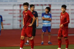 Hậu vệ Tấn Sinh (trái) và tiền vệ Trọng Hùng chấn thương. (Ảnh: Hoàng Linh/TTXVN)