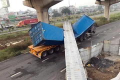 Xe container bị dầm bêtông đè lên dập móp. (Ảnh: TTXVN phát)