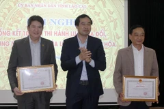 Phó Chủ tịch UBND tỉnh Lào Cai Trịnh Xuân Trường tặng Bằng khen cho các cá nhân và tập thể tiêu biểu có thành tích xuất sắc trong công tác thi hành Luật sửa đổi một số điều của Luật Di sản văn hóa. (Ảnh: Quốc Khánh/TTXVN)