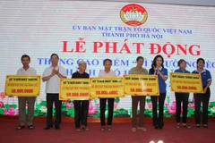 Đại diện Ủy ban Mặt trận Tổ quốc Việt Nam thành phố Hà Nội trao kinh phí hỗ trợ xây 5 nhà "Đại đoàn kết" cho các hộ nghèo. (Ảnh: Nguyễn Thắng/TTXVN)