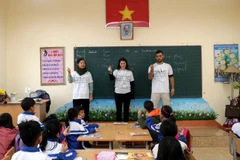 Các tình nguyện viên hướng dẫn các em học sinh trường Tiểu học và THCS Lê Văn Tám (thị trấn Sa Pa) học văn hóa bằng tiếng Anh. (Ảnh: Quốc Khánh/TTXVN)