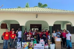 Đoàn công tác của Hội phụ nữ Việt Nam tại Tanzania với nhân viên và trẻ em của Trại trẻ em Kamelot. (Ảnh: Đình Lượng/TTXVN)