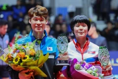 Vận động viên Jang Woo-jin của Hàn Quốc và Cha Hyo-sim của Triều Tiên giương cao chiếc cúp hạng hai của họ trong đôi nam nữ trong lễ trao giải tại Liên đoàn bóng bàn quốc tế World Tour Grand Finals tại Namdong Gymnasium ở Incheon, cách Seoul 40km về phía 