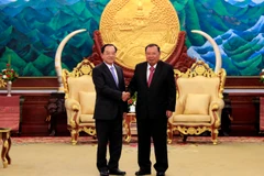 Tổng Bí thư, Chủ tịch nước Lào Bounnhang Vorachith tiếp thân mật ông Đào Việt Trung. (Ảnh: Phạm Kiên/Vietnam+)