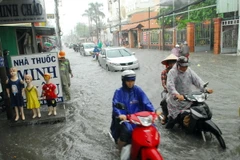 Mưa ngập đường Phan Huy Ích (thuộc quận Tân Bình và Gò Vấp) khiến giao thông ngặp nhiều khó khăn, hàng trăm phương tiện bị chết máy. (Ảnh: Mạnh Linh/TTXVN)