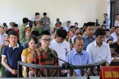 Bị cáo Nguyễn Ngọc Minh (Minh Sâm - áo xanh) và các đồng phạm khác trước vành móng ngựa. (Ảnh: Thái Hùng/TTXVN)