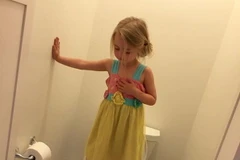 Cô bé 3 tuổi Chandler đang giữ thăng bằng trên bệ toilet. (Nguồn: Facebook)