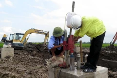 Đơn vị kiểm định chất lượng bêtông tiến hành khoan trụ bêtông cột điện cao thế để lấy mẫu kiểm định chất lượng. (Ảnh: Văn Đạt/TTXVN)