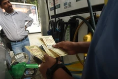 Khách hàng đổ xăng tại một trạm xăng ở New Delhi của Ấn Độ. (Ảnh: AFP/TTXVN)