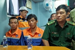 Bộ đội Biên phòng Đồn Phước Tỉnh, huyện Long Điền, đến tiếp nhận hai ngư dân. (Ảnh: Đoàn Mạnh Dương/TTXVN )