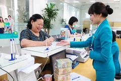 Giao dịch tại ngân hàng. (Ảnh: Vietnam+)