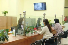 Hàng tháng, Ngân hàng Chính sách chi trả đến người lao động bị ngừng việc qua tài khoản hoặc tại trụ sở. (Ảnh: CTV/Vietnam+)