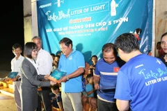 Bà Nguyễn Thị Hương, Phó Tổng giám đốc ABBANK trao quà cho người dân Bình Phước. (Ảnh: CTV/Vietnam+)