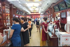 Nhiều người dân xếp hàng mua bán vàng tại Bảo Tín Minh Châu trên phố Trần Nhân Tông, Hà Nội chiều ngày 6/8. (Ảnh: PV/Vietnam+)