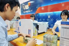 Giao dịch tại ngân hàng. (Ảnh: CTV/Vietnam+)