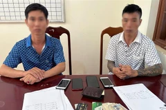Hai đối tượng Đào Văn Khắc và Đào Văn Cương tại cơ quan công an. (Ảnh: TTXVN phát)